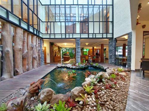 a large indoor pool in a house with rocks at The Batu Hotel & Villas in Batu