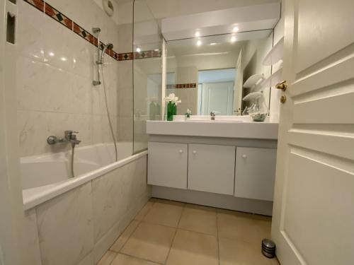 une salle de bain avec une baignoire, un lavabo et un miroir dans l'établissement 1 Bed apt center Cannes conference center - 2005, à Cannes