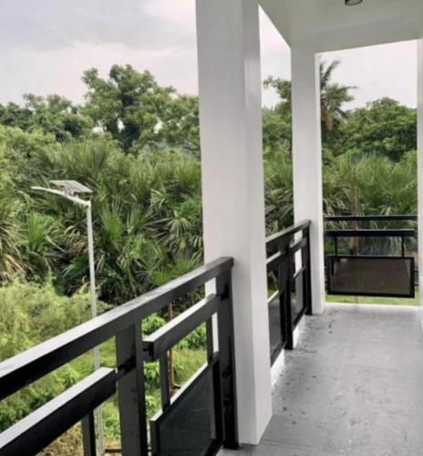 a balcony with a view of the forest at Rold and Roub Home Suites powered by Cocotel in Puerto Galera