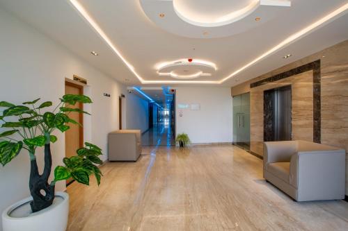 an office lobby with a couch and a plant at HOTEL BLUEMOON in Tirunelveli
