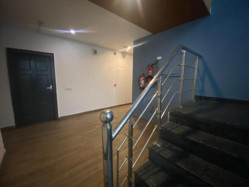 a staircase in a room with a door and a stair railing at Divine Inn Couple Friendly Hotel near Sector 51 Metro Station in Noida
