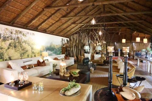 - un salon avec un canapé et une table dans l'établissement Karongwe Portfolio - Chisomo Safari Camp, à Karongwe Game Reserve