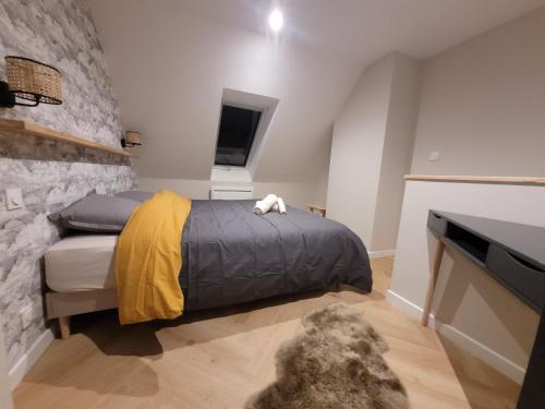 a bedroom with a bed and a stone wall at Les apparts de Léon in Landerneau