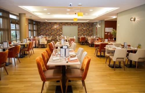 a dining room with tables and chairs and tablesktop at Domitys Le Phare d'Argent in Cherbourg en Cotentin