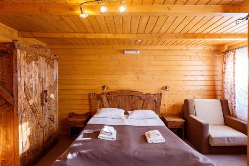 a bedroom with a bed and a chair in a cabin at GORGANY resort & SPA in Yablunytsya