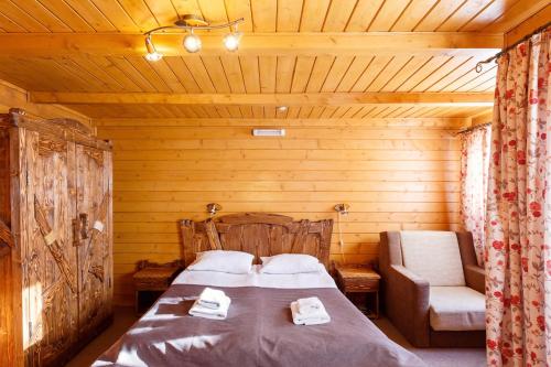 a bedroom with a bed and a chair in a room at GORGANY resort & SPA in Yablunytsya