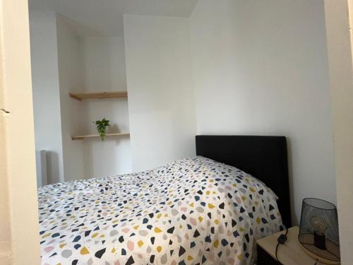 Schlafzimmer mit einem Bett mit Polka-Punkten-Bettwäsche in der Unterkunft Le Montgy - Studio tout confort à Royat National N1 in Royat
