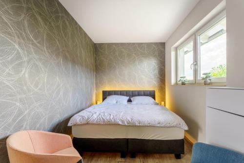 um quarto com uma cama e uma cadeira em Ferienhaus Stilloft One em Wernigerode
