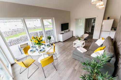 een woonkamer met een bank en een tafel met gele stoelen bij Ferienhaus Stilloft One in Wernigerode