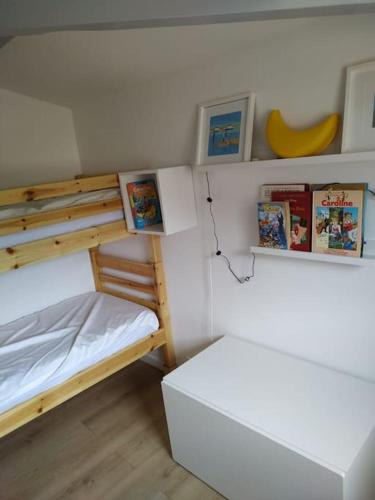 - une petite chambre avec des lits superposés et une table dans l'établissement Maisonnette Les Palombes, à Lacanau