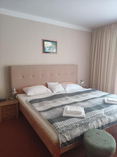 a bedroom with a large bed with a blanket at Panoramic-Oscar in Mrągowo