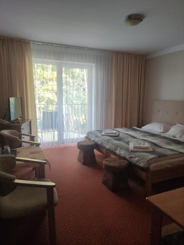 a hotel room with a bed and a large window at Panoramic-Oscar in Mrągowo