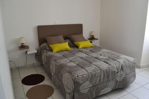 - une chambre avec un grand lit et 2 oreillers jaunes dans l'établissement maison de vacances Nébouzat, à Nébouzat