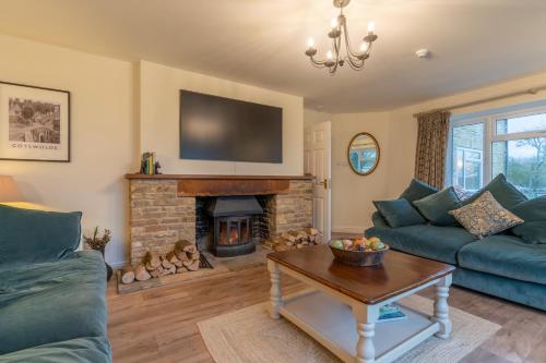 a living room with a couch and a fireplace at Banbury Hill Farmhouse in Charlbury