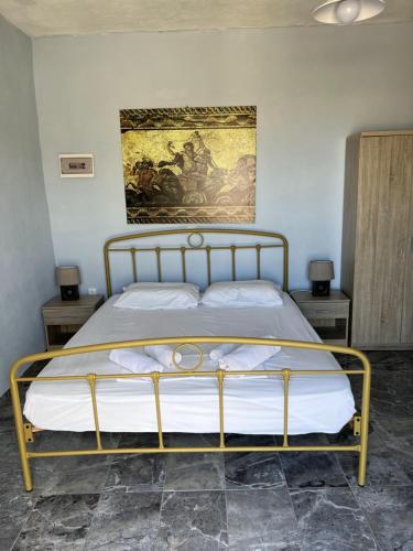 a bed in a bedroom with a painting on the wall at Villa Hellas in Afiartis