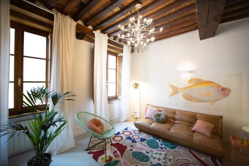 a living room with a couch and a fish painting on the wall at La Corticella Luxury Suite, with Terrace in Lucca
