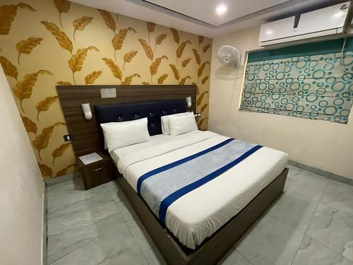 a bedroom with a bed with a blue and white blanket at Hotel Baba - near Charbagh Railway Station in Lucknow