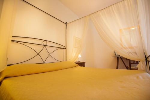 a bedroom with a large bed with a yellow blanket at Agriturismo La Vecchia Fattoria in Orte
