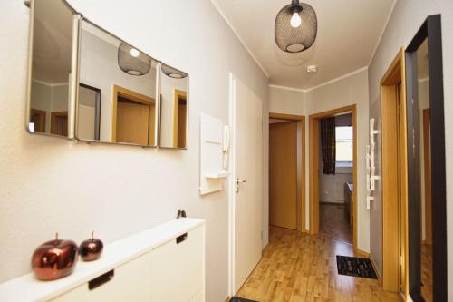 a bathroom with a sink and mirrors on the wall at hafennahe Ferienwohnung mit Balkon und Meerblick - Hafenhäuser Breege FeWo 11 in Breege