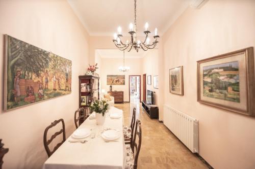 ein Esszimmer mit einem Tisch und einem Kronleuchter in der Unterkunft Re Migio Apartment with Terrace and Lift in Lucca