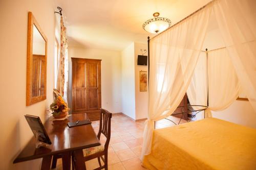 a bedroom with a bed and a desk with a laptop at Agriturismo La Vecchia Fattoria in Orte