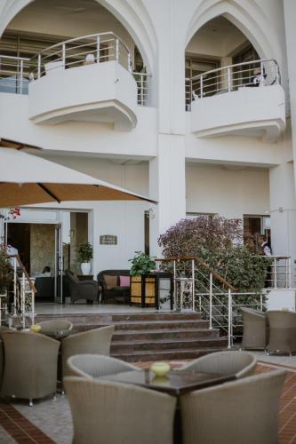 a lobby with tables and chairs and a building at Palm Djerba Suites in Mezraya