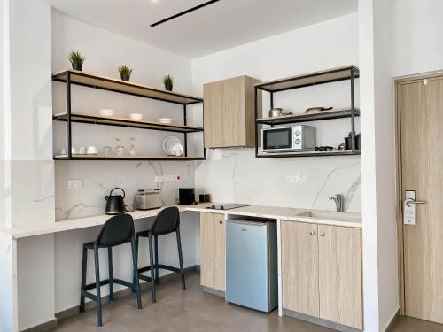 a kitchen with two bar stools and a counter top at Caramela Luxury Apts in Ayia Napa