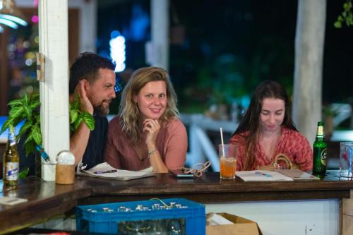 a group of people sitting at a table at Tiki Beach Koh Phangan Beach Restaurant Bar and Coworking in Ban Tai
