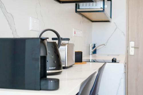a kitchen counter with a tea kettle and a sink at Caramela Luxury Apts in Ayia Napa