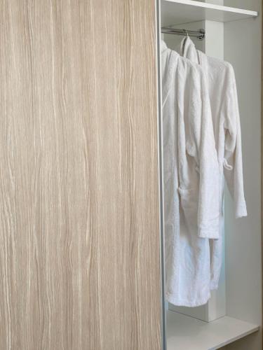 a closet with white towels hanging on a rack at Caramela Luxury Apts in Ayia Napa