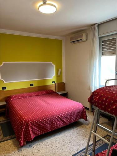 a bedroom with a red bed and a green wall at Hotel San Marco BB in Boario Terme