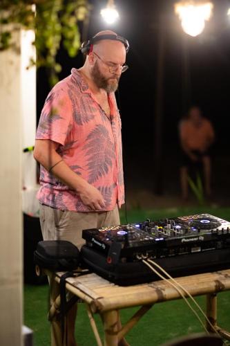 a man standing next to a table with a keyboard at Tiki Beach Koh Phangan Beach Restaurant Bar and Coworking in Ban Tai