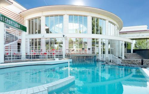 un bâtiment avec une piscine en face d'un bâtiment dans l'établissement Holiday Club Katinkulta Apartments, à Vuokatti