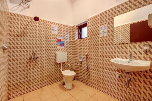 a bathroom with a toilet and a sink at goSTOPS Goa, Calangute in Calangute