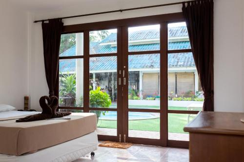 a bedroom with a large sliding glass door at Tiki Beach Koh Phangan Beach Restaurant Bar and Coworking in Ban Tai
