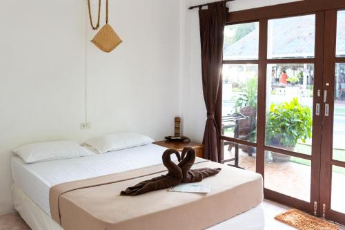 a bedroom with a bed and a large window at Tiki Beach Koh Phangan Beach Restaurant Bar and Coworking in Ban Tai