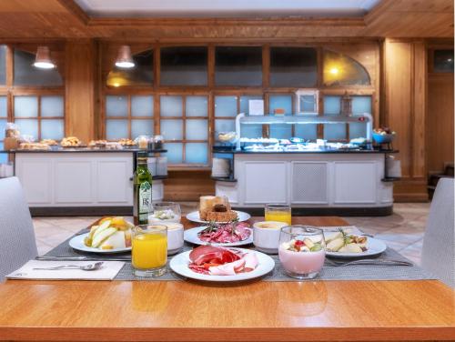 a table with plates of food and drinks on it at Hotel Vielha Val d'Aran, Affiliated by Meliá in Vielha