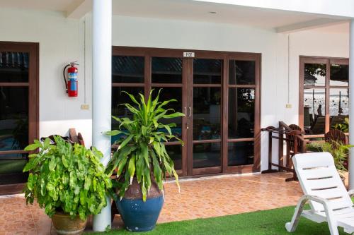 a house with two potted plants in front of a door at Tiki Beach Koh Phangan Beach Restaurant Bar and Coworking in Ban Tai