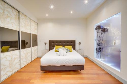 une chambre avec un lit et une grande fenêtre dans l'établissement LE FRANKLIN - Magnifique T2bis - Place des Grands Hommes, à Bordeaux