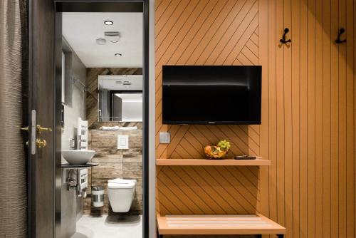 a bathroom with a toilet and a television on a wall at Victoria Interpark Hotel 