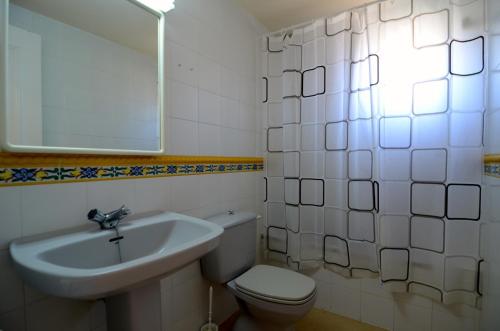 a bathroom with a sink and a toilet and a mirror at Terrassa del Mar 6-1-B in L'Escala