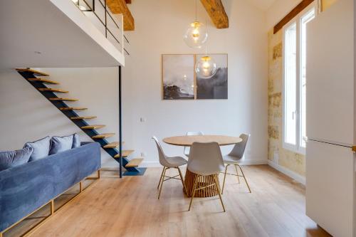 un salon avec une table et un canapé bleu dans l'établissement Le Méli Mélo - Superbe T2 - Bail Mobilité, à Bordeaux