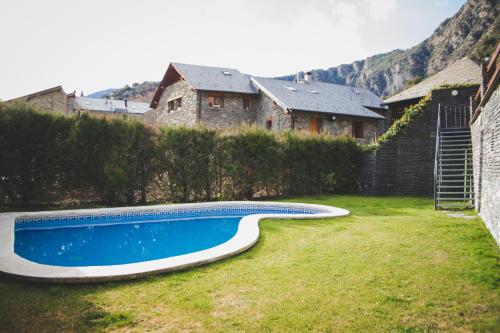 a swimming pool in a yard next to a house at Casa Samarra in Vall de Cardos