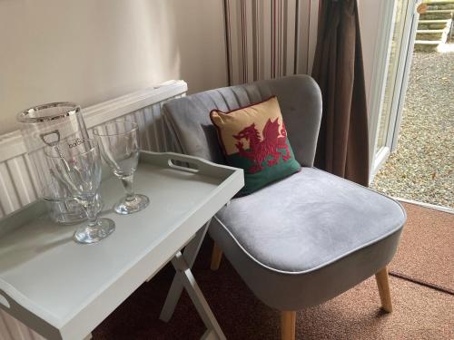 a chair sitting next to a white table with a pillow at Talybont Bed and Breakfast in Barmouth