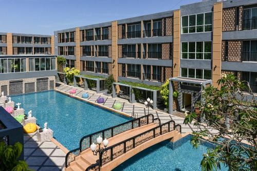 an apartment building with a swimming pool in front of a building at Golden Sea Hua Hin - SHA Extra Plus in Hua Hin