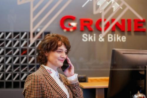 a woman is sitting in front of a computer at Gronie Ski & Bike in Szczyrk