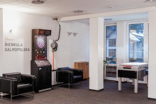 a room with a video game machine and chairs at Gronie Ski & Bike in Szczyrk