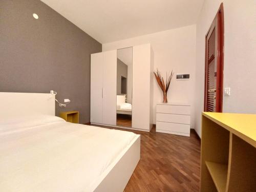 a bedroom with a white bed and a mirror at Residenze La Madonnina in Vigatto