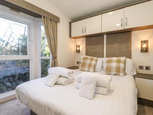 a bedroom with a bed with white pillows and a window at Hercules in Morpeth