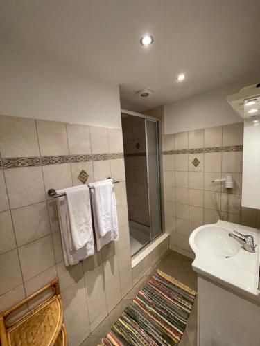 a bathroom with a sink and a shower with towels at Waldrestaurant VIDA in Kapfenberg